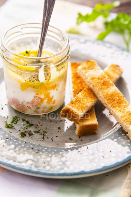 Coddled eggs with ham in jar, cheese and cut toast — Stock Photo