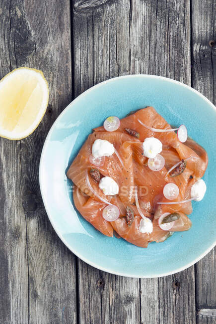 Smoked salmon platter with capers, radish, onions and cheese - foto de stock