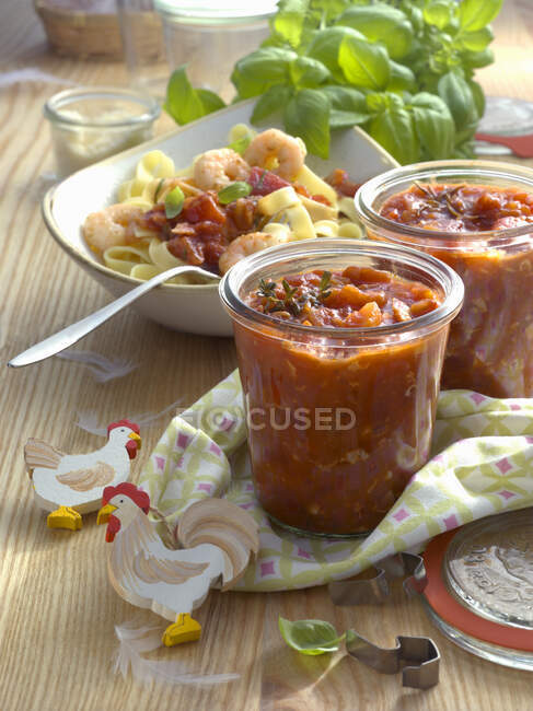 Tagliatelle with arrabbiata sauce and shrimps and gazpacho in jars — Stock Photo