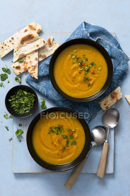 Vegan coconut and butternut squash soup with coriander and flatbreads — Stock Photo