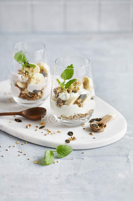 Banana Skyr trifle in a glass on a white marble plate — Stock Photo