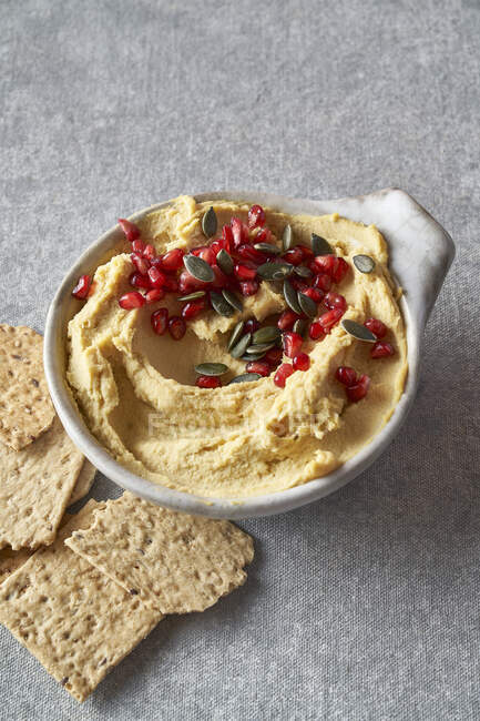 Hummus with pomegranate and pumpkin seeds — Stock Photo