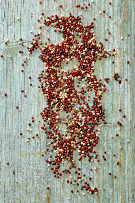 Sementes de pimenta vermelha e branca em um fundo de madeira — Fotografia de Stock