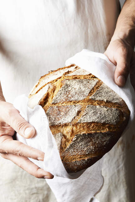 Colpo ritagliato di persona che tiene il pane appena sfornato — Foto stock