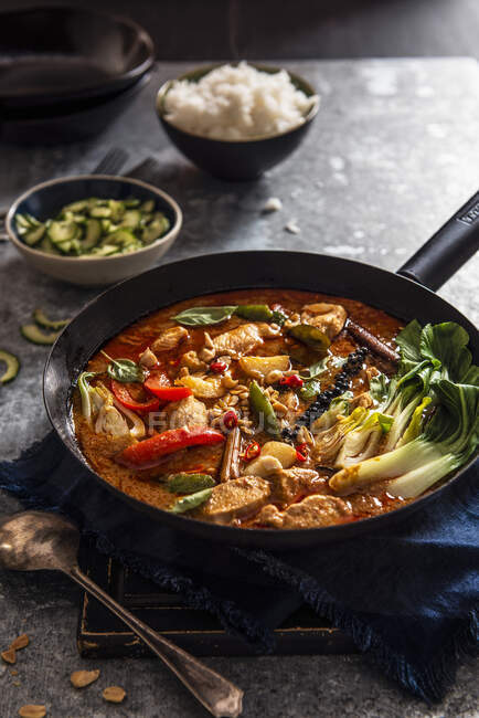 Thai Massaman chicken curry with peanuts, new potatoes, peppers, pak choy, thai lime cucumber relish and jasmin rice — Stock Photo