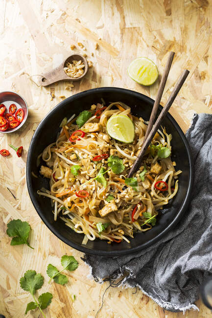 Tigela escura de comida de rua tailandesa, tofu, macarrão e legumes — Fotografia de Stock