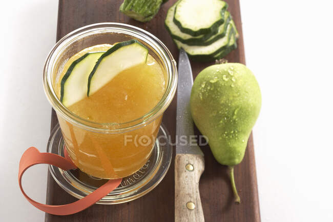 Homemade pears and courgettes jam in glass jar and fresh ingredients on wooden board — Stock Photo