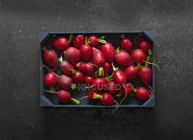 Radishes in a wooden crate — Stock Photo