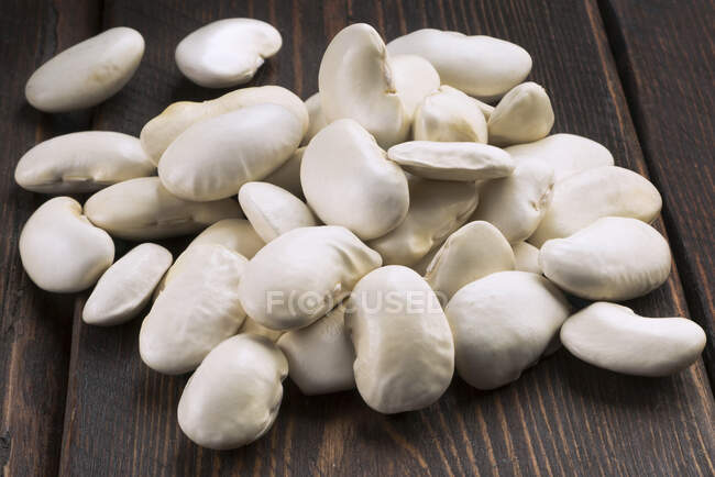 Heap of crown beans on a rustic wooden table — Stock Photo