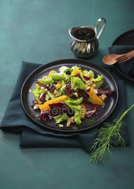 Salat, Radicchio und Orangenfilets mit Orangen-Dill-Dressing, karamellisierten Walnüssen und Kürbiskernen — Stockfoto