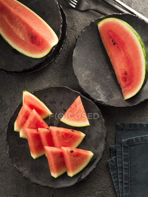 Slices of watermelon on black ceramic plate — Stock Photo