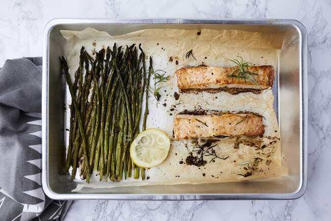 Salmon and asparagus baked in the oven, seasoned with olive oil and rosemary — Stock Photo