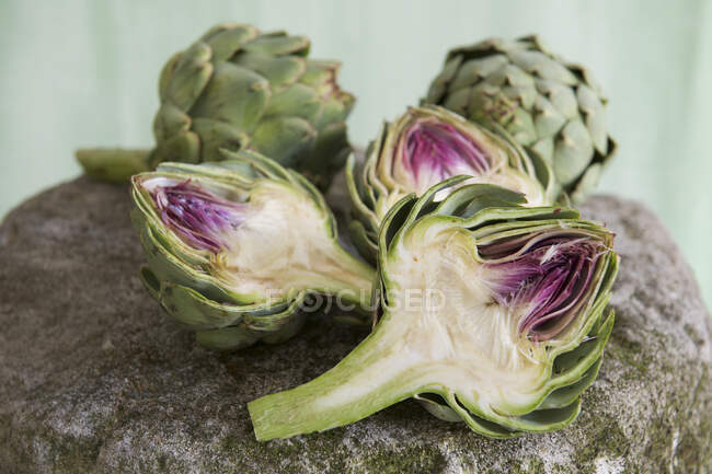 Fresh green artichoke with leaves on wooden background — Stock Photo