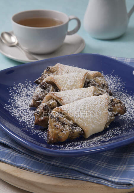 Vanilla and chocolate rolls served on plate with powdered sugar — Stock Photo