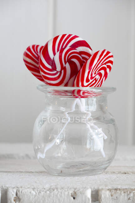 Red and white swirl lollies in a glass jar — Stock Photo