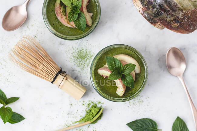 Matcha panna cotta with peaches and mint in glass jars — Stock Photo