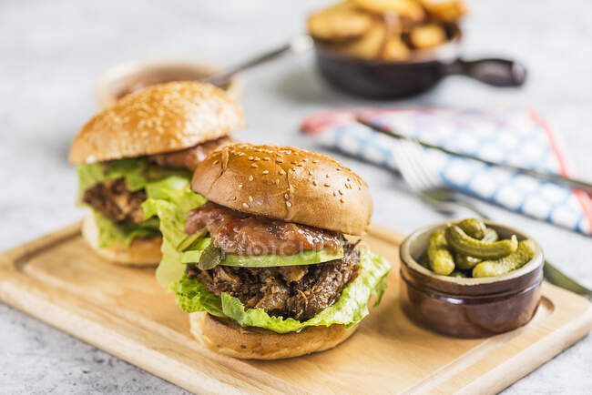 Burgers with avocado and gherkins — Stock Photo