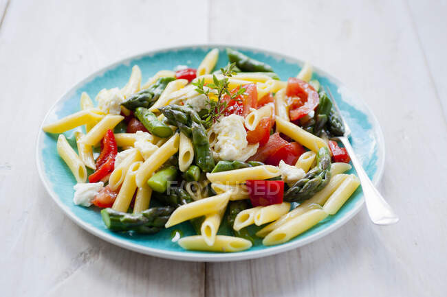 Pasta salad with asparagus and tomatoes, close up shot — Stock Photo