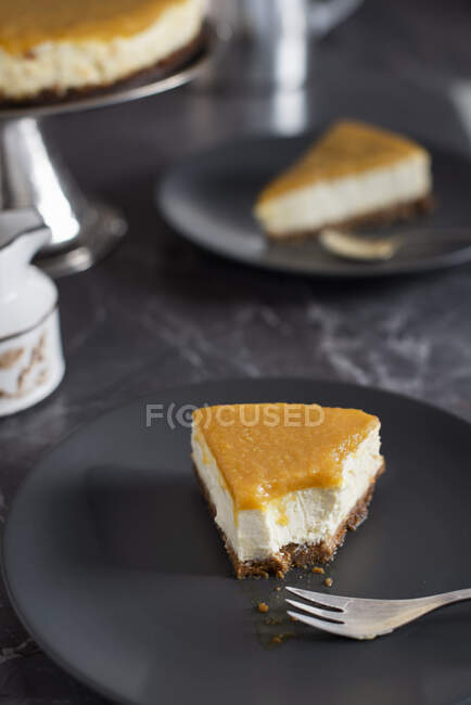 Piece of cheesecake with mango jelly, half eaten — Stock Photo