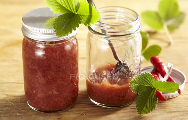 Chutney saboroso com morangos, pimenta e malabar pimenta em frascos de vidro — Fotografia de Stock