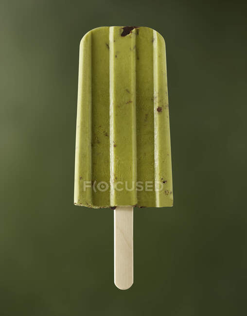 Anacardo matcha en un palo sobre un fondo verde - foto de stock