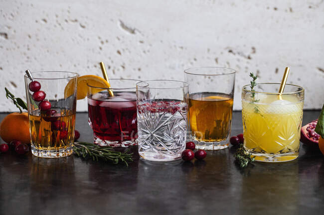 Varie bevande alcoliche con whisky, bourbon, vodka, mirtilli rossi, arance, melograni, rosmarino e timo — Foto stock