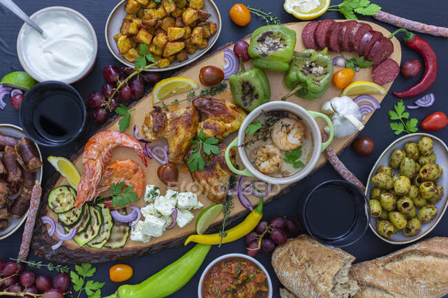 Antipasti plate with various vegetables, shrimps, dips, fruit, bread and chicken — Stock Photo