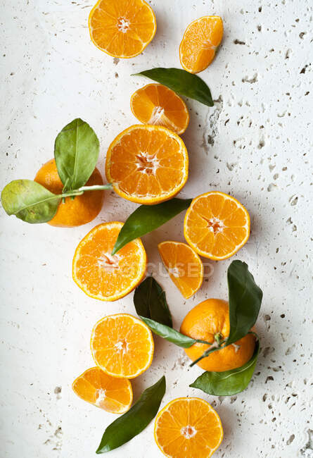 Апельсины с листьями, целые, половинчатые и ломтики — стоковое фото