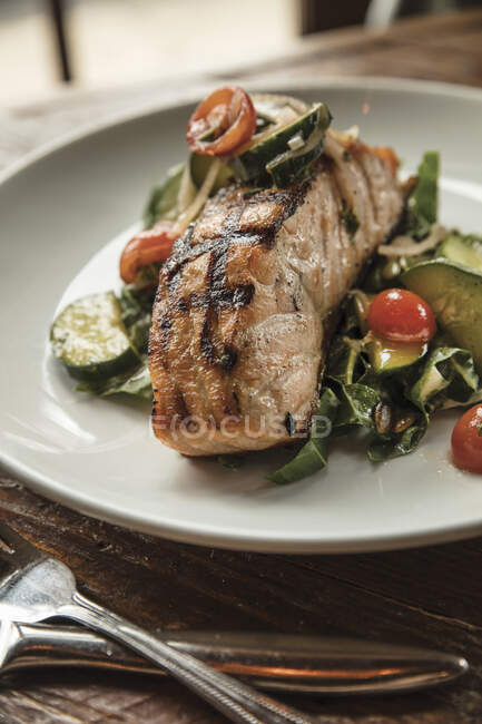 Woodfire-grilled salmon with Swiss chard and tahini salad, tomato and cucumber — Fotografia de Stock