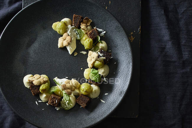 Deconstructed gooseberry fool with spiced ginger cake, baked white chocolate and basil nut — Stock Photo