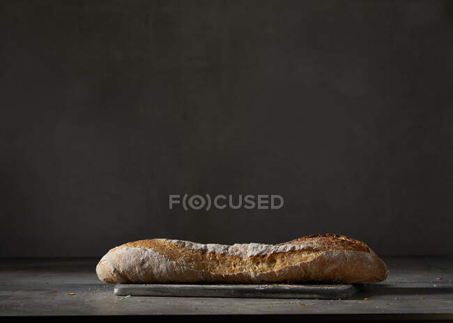 A baguette in front of a dark background — Stock Photo