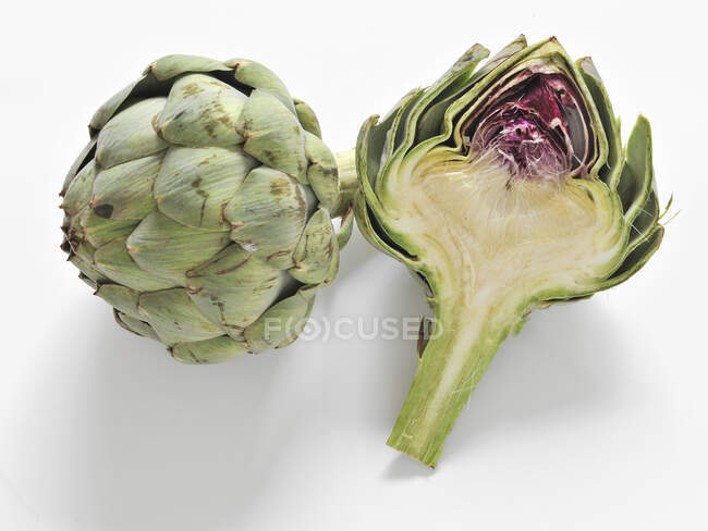 Artichoke, whole and halved on a white background — Stock Photo