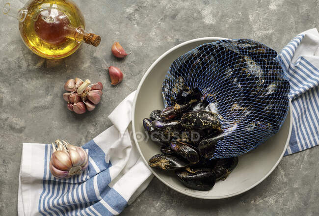 Fresh raw sea mussels with garlic ready to be cooked — Stock Photo
