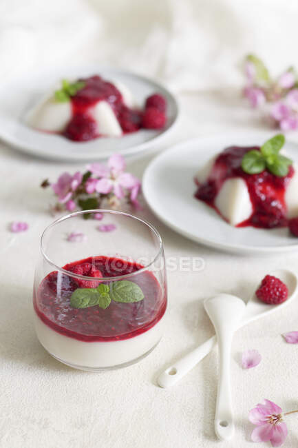 Vegan panna cotta with raspberries mousse in glass and on plates — Stock Photo