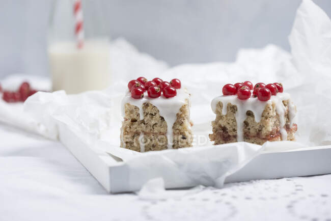Vegan almond sponge cake with redcurrant jam, icing and fresh fruits — Stock Photo