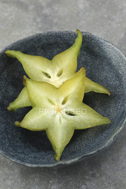 Fatias de frutas carambola em pequena tigela de cerâmica — Fotografia de Stock