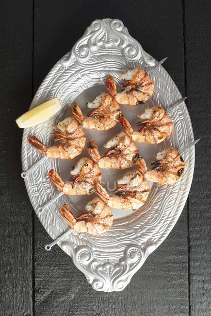 Skewered shrimp on platter — Stock Photo
