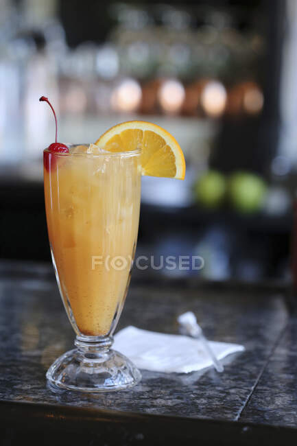 Bicchiere di Rum punch su barra con fetta di arancia e guarnizione di ciliegie — Foto stock