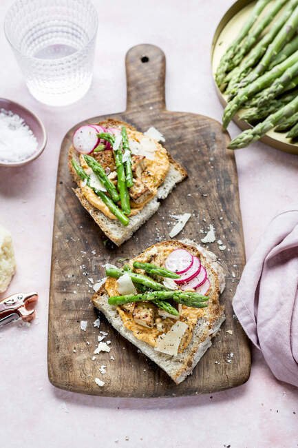 Sandwiches abiertos con pimentón, hummus y espárragos - foto de stock