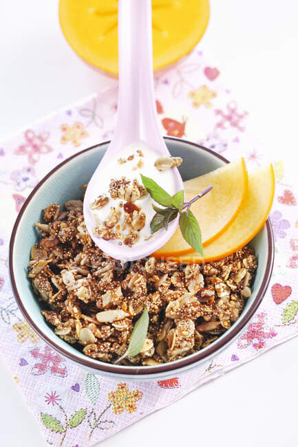 Roasted muesli with amaranth, sesame seeds, sunflower seeds and honey served with fruit and yoghurt — Stock Photo