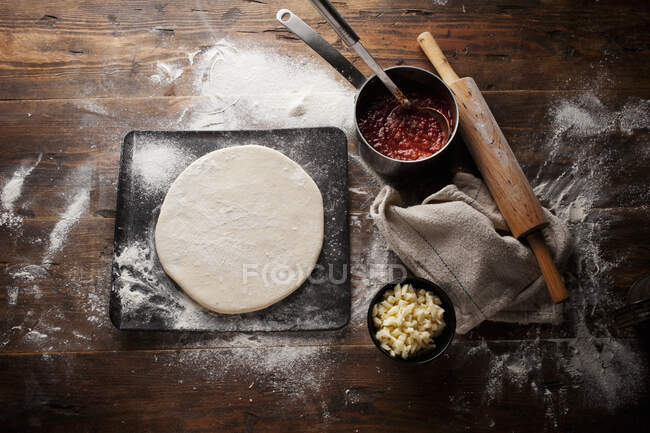Pasta per pizza cruda sul tavolo, primo piano — Foto stock