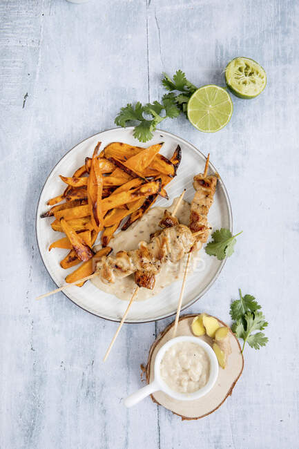 Chicken kebabs with peanut sauce and sweet potato wedges — Photo de stock