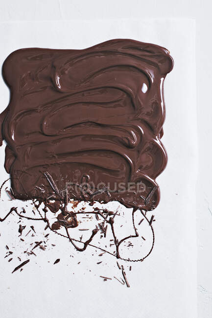 Liquid chocolate spread and blobbed on a white surface — Stock Photo