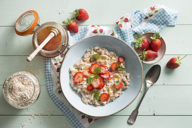 Porzione di porridge con fragole, miele e menta — Foto stock