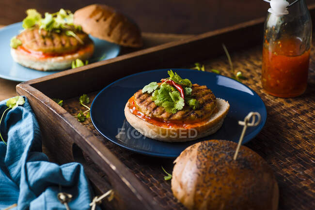 Curry chicken burger with sweet chili sauce and fresh coriander — Stock Photo