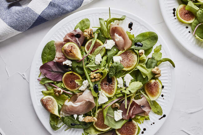Salade aux figues fraîches, prosciutto, fromage de chèvre et noix — Photo de stock
