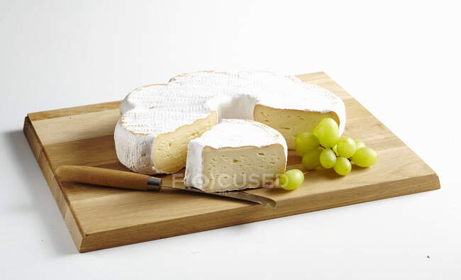 Saint Albray, soft cheese from France served on wooden board with grapes — Stock Photo