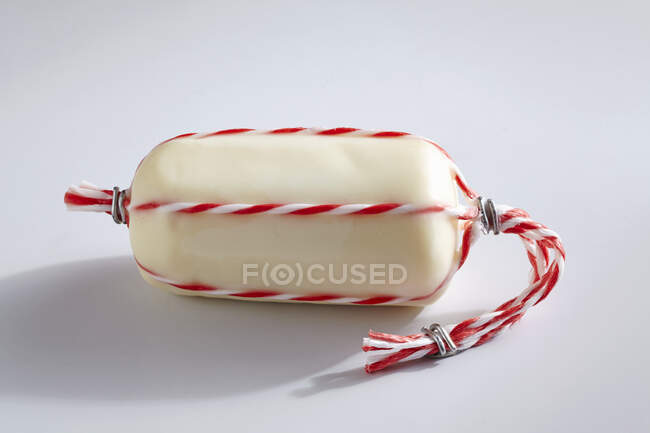 Provolone Topolino cheese wrapped in wax with string — Stock Photo