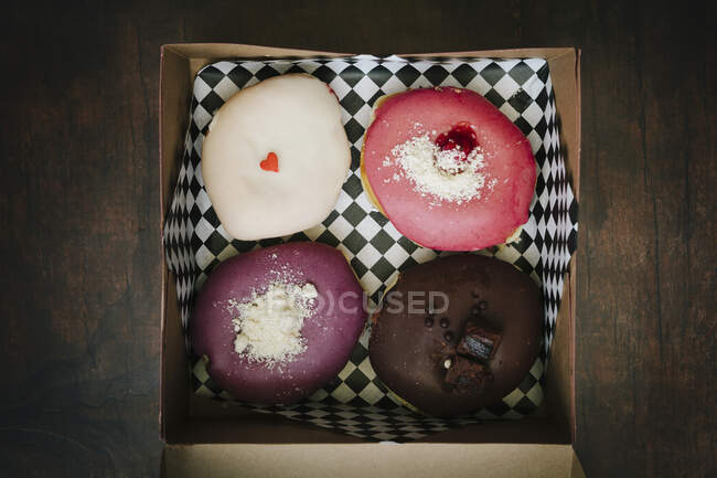 Чотири смачні пончики в коробці — стокове фото