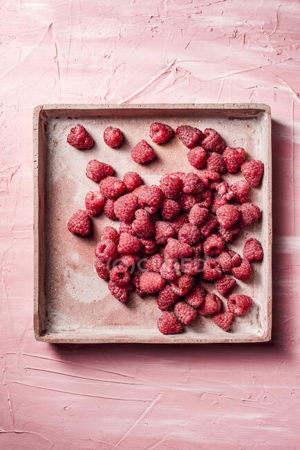 Fresh raspberries in square ceramic tin — Stock Photo